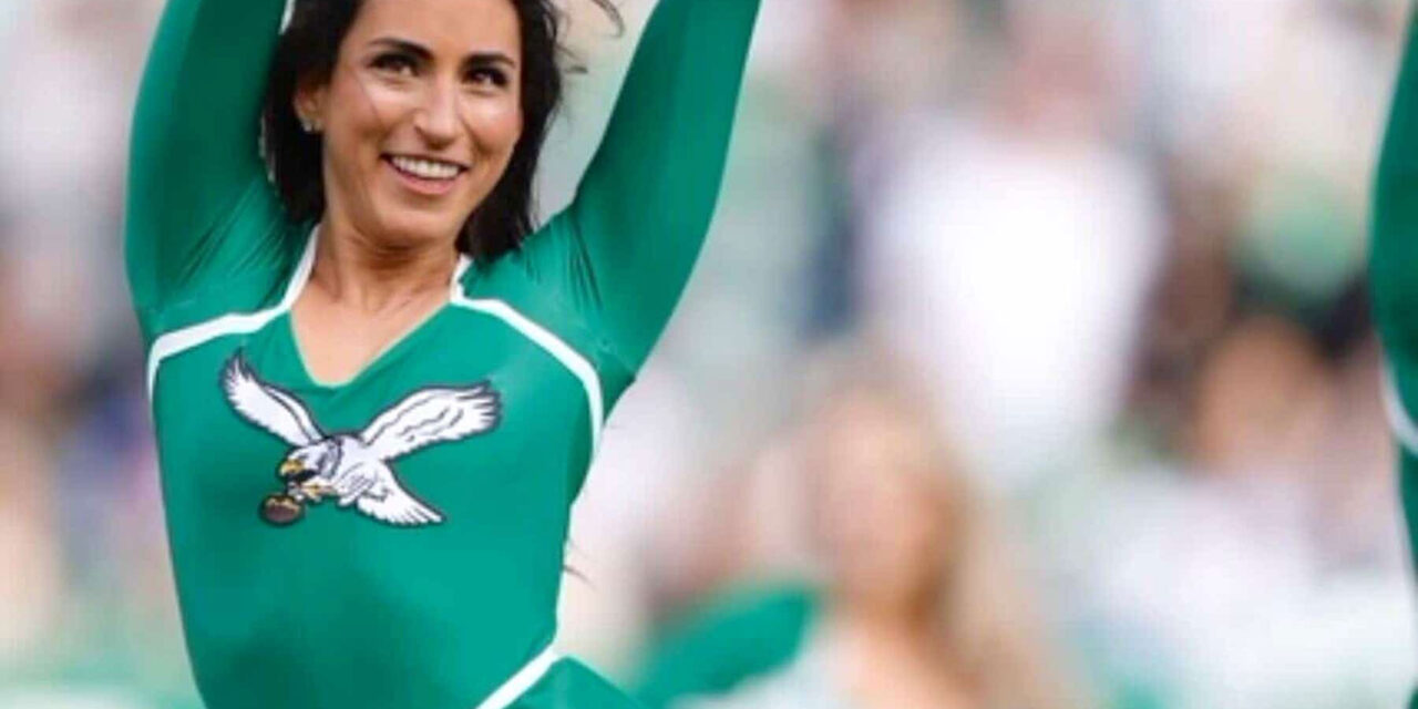 Pom-poms waving, a Philadelphia Eagles cheerleader leans into her Judaism