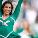 Pom-poms waving, a Philadelphia Eagles cheerleader leans into her Judaism